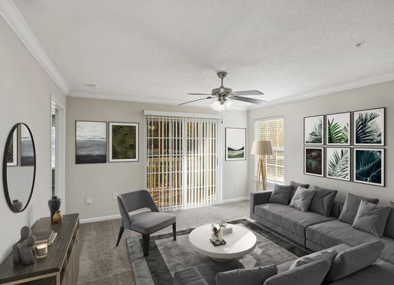 Model Living Room with Carpet and Patio Accessibility at Shadow Ridge Apartments in Riverdale, GA.