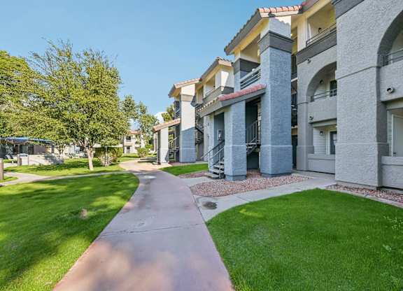 Walkway leading between two rows of apartment buildings.