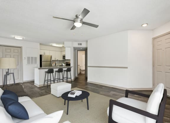 Model living room with white couch and chair at Retreat at Crosstown Apartments