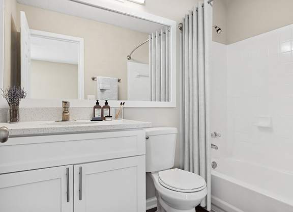 Model Bathroom with White Cabinets, Wood-Style Flooring and Shower/Tub at Element 41 Apartments located in Marietta, GA.