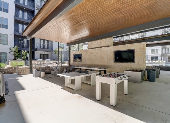 a patio with tables and chairs and a flat screen tv