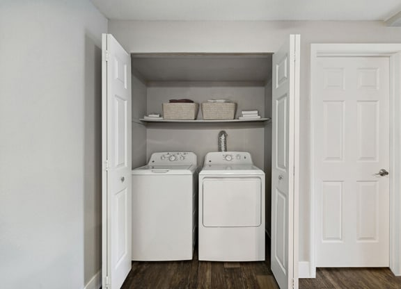 Model Laundry Room with Wood-Style Flooring at Central Flats Apartments in Kent, WA.