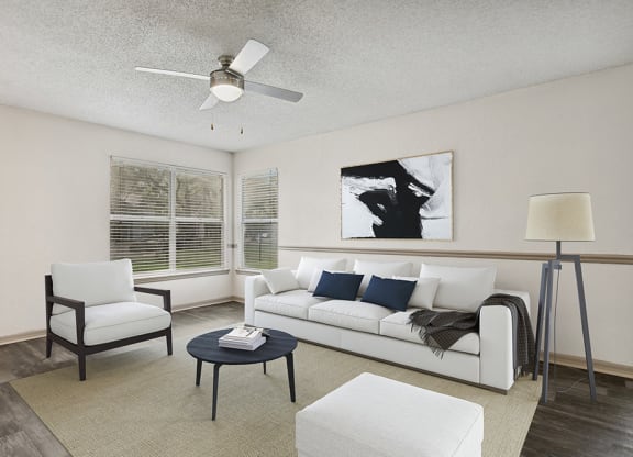 Model living room with a white couch and a black coffee table at Retreat at Crosstown Apartments