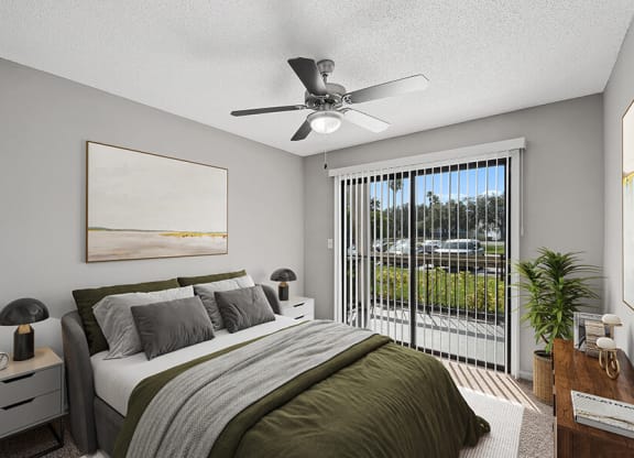 Model Bedroom with Carpet and Patio Accessibility at Fountains Lee Vista Apartments in Orlando, FL.