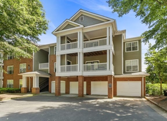 Apartment exterior showcasing garages on first floor of three story building