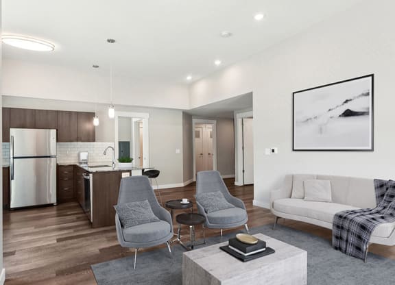 Model Living Room with Wood-Style Flooring and View of Kitchen at Seven Skies Apartments located in Sandy, UT.