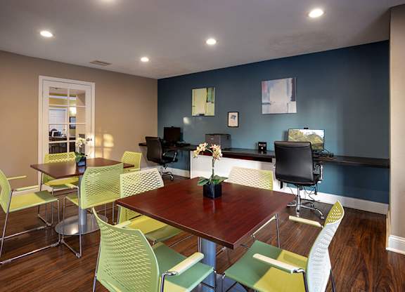 A dining room with a table surrounded by chairs.