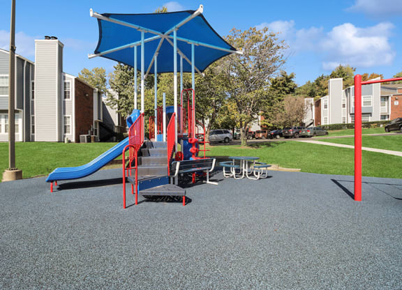 Community Playground with Slide, Swing Set and Blue Canopy at Abbington Heights Apartments in Antioch, TN.