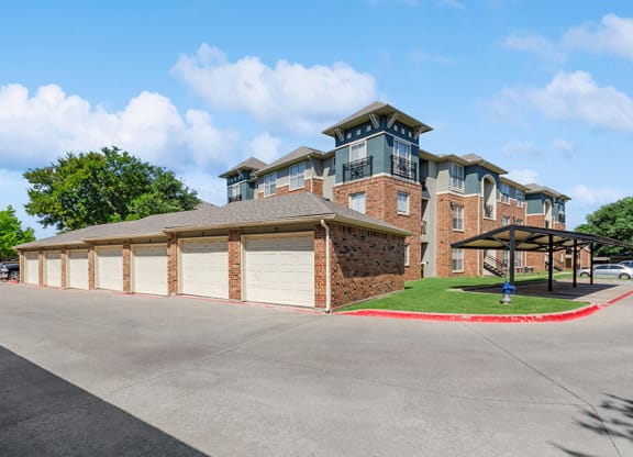 Exterior Community Building and Garages at Belmont at Duck Creek Apartments in Garland, TX.
