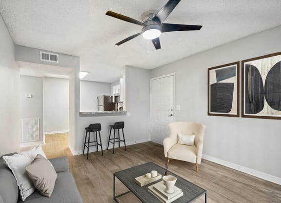 Model Living Room with Wood-Style Flooring and View of Kitchen at Westland Park Apartments in Jacksonville, FL.