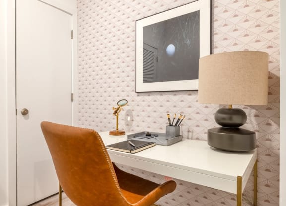 Model room with desk with a lamp and a chair in a room