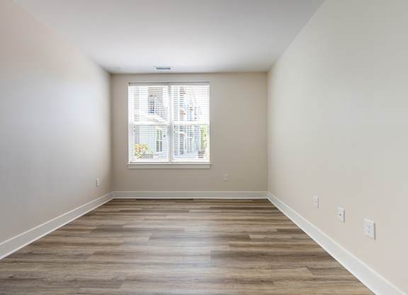 A room with wooden floors and a window.