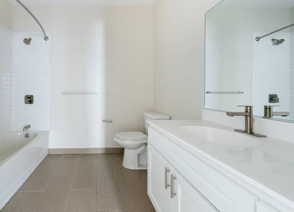 A white bathroom with a toilet, sink, and bathtub.