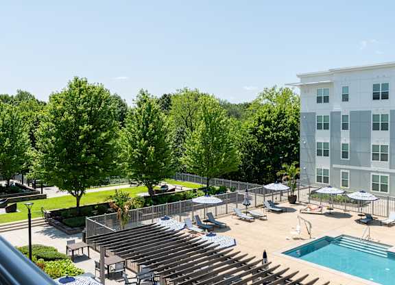 A large building with a pool and a lot of trees.