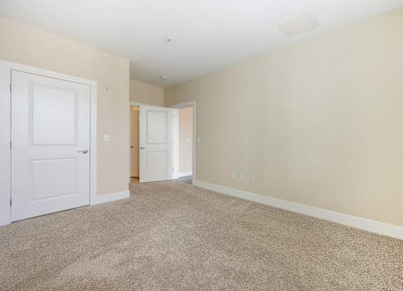 A room with beige walls and carpeted floor.