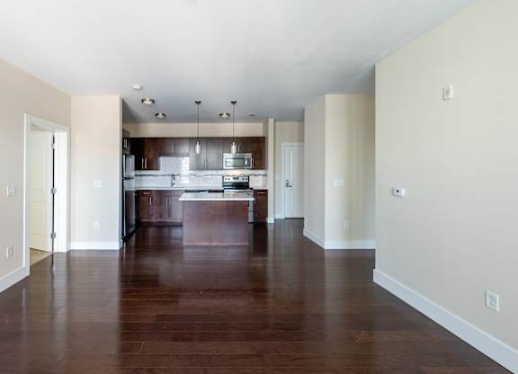 A kitchen with a wooden floor and white walls.