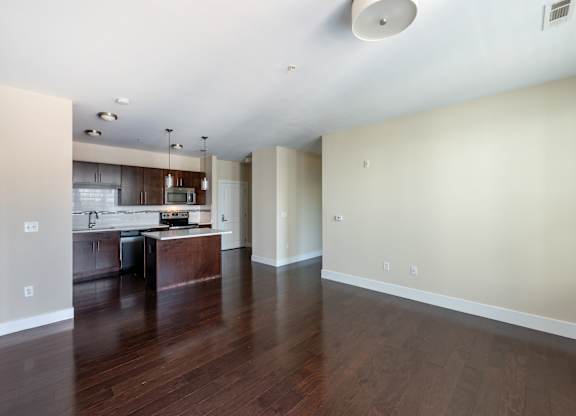 A kitchen with a wooden floor and white walls.