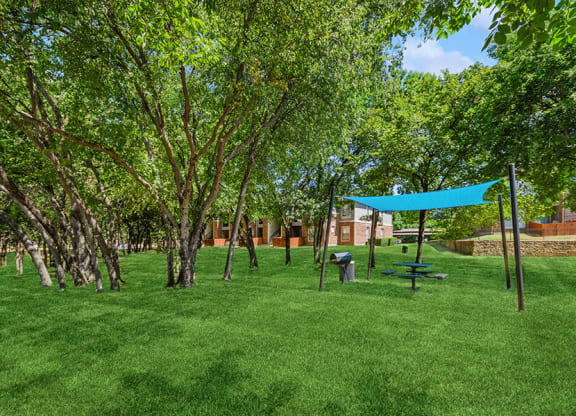 Outdoor BBQ Area with Canopy at Belmont at Duck Creek Apartments in Garland, TX.