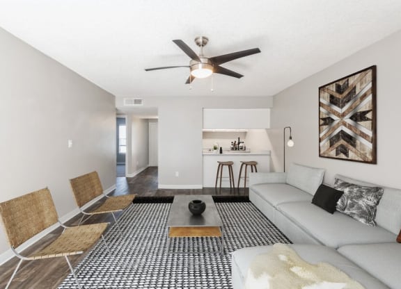 Model Living Room with Wood-Style Flooring and Kitchen View at Indigo Park Apartments in Albuquerque, NM.