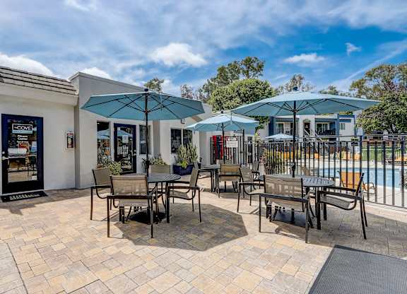 Community Picnic Tables with Umbrellas at Cove La Mesa Apartments located in La Mesa, CA.