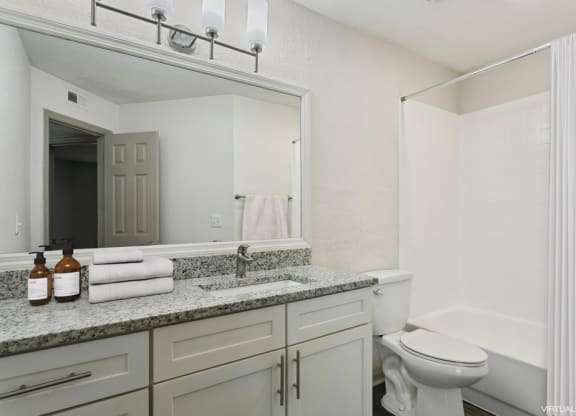 Model bathroom with a sink, toilet, and bathtub at Retreat at Crosstown Apartments