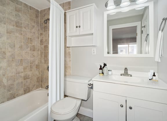 Model bathroom with a toilet, sink, and bathtub