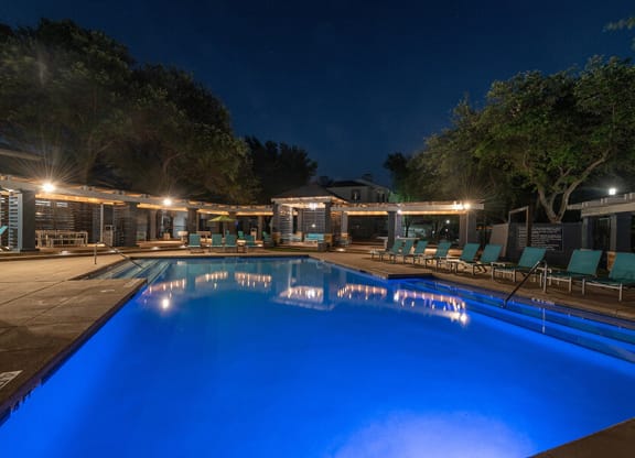 Community Swimming Pool with Pool Furniture at Essence North Dallas Apartments located in Dallas, TX.