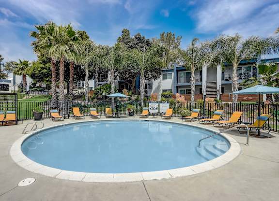 Community Swimming Pool with Pool Furniture at Cove La Mesa Apartments located in La Mesa, CA.