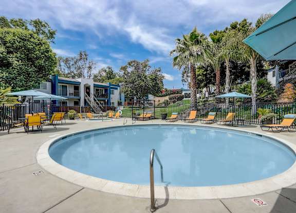 Community Swimming Pool with Pool Furniture at Cove La Mesa Apartments located in La Mesa, CA.