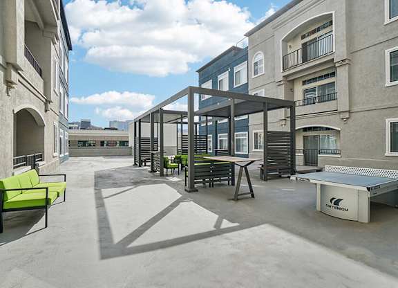 Rooftop Patio with Lounge Furniture, a Ping Pong Table, and Cornhole at Altitude on Fifth Apartments located in Salt Lake City, UT.
