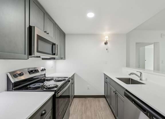 A modern kitchen with a stove top oven and microwave.