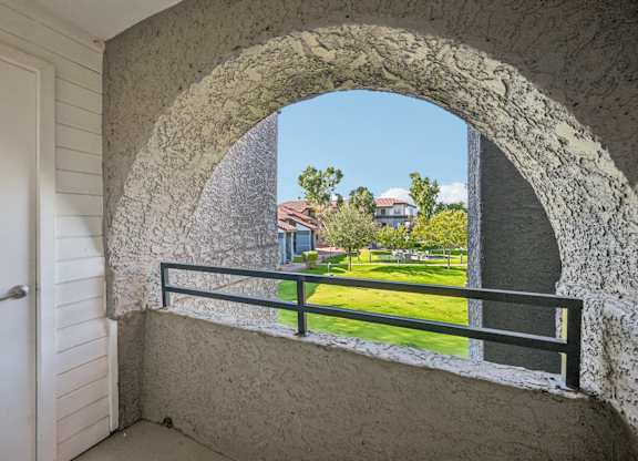 Model balcony with a view of a building and trees.