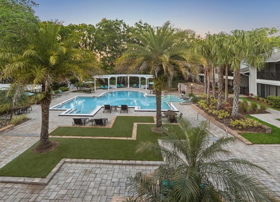 Aerial View of Community Swimming Pool with Pool Furniture at Grand Pavilion Apartments in Tampa, FL.
