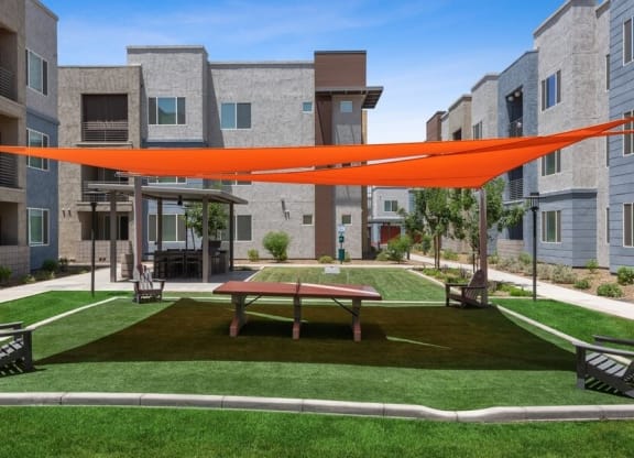 Community outdoor gaming area with covered ping pong table