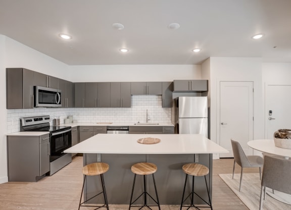 a kitchen with a white counter top and stainless steel appliances