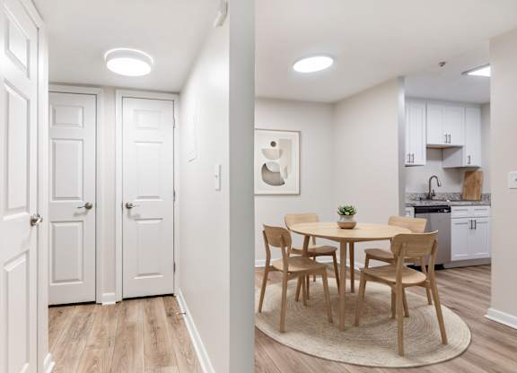 A white kitchen with a table and chairs.