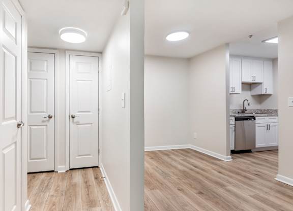 A kitchen area with white cabinets and a dishwasher.