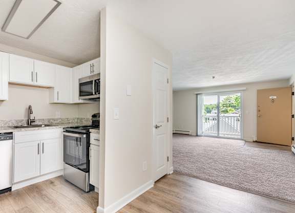 A kitchen with white cabinets and a black stove top oven.