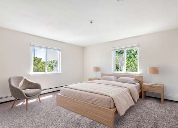 A bedroom with a bed, chair, and two windows.