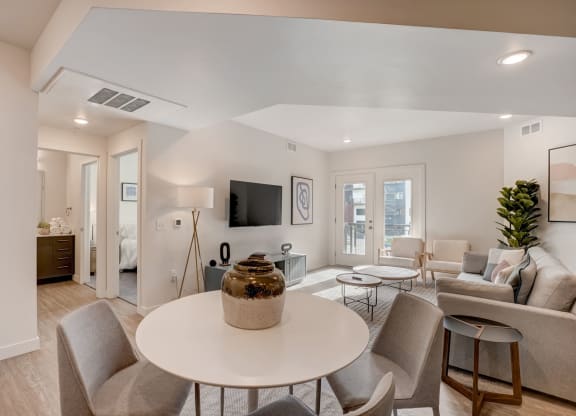 a living room with a round table and chairs and a couch