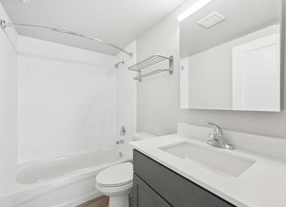 A white bathroom with a toilet, sink, and bathtub.