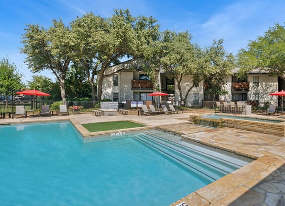 Community Swimming Pool with Pool Furniture at Summit Ridge Apartments located in Arlington, TX.