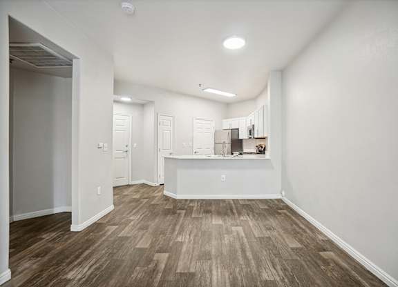 Model Living Room and Kitchen with Wood-Style Flooring at Altitude on Fifth Apartments located in Salt Lake City, UT.
