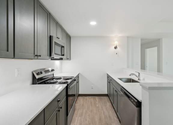 A kitchen with black cabinets and white countertops.