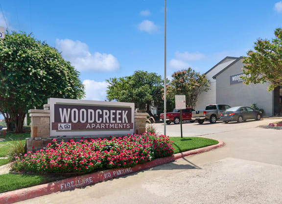 Community Monument Sign and Landscape at Woodcreek Apartments located in Arlington, TX.