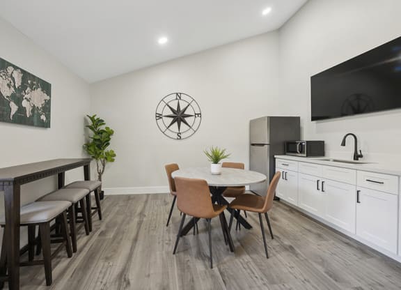 Community Clubhouse with Kitchenette Area and TV at Villages at Metro Center Apartment located in Phoenix, AZ.