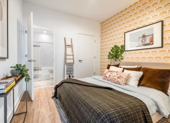 Model bedroom with a bed and attached bathroom