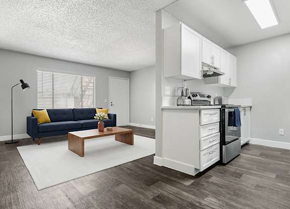 Model Living Room & Kitchen with Wood-Style Flooring at Accent on Rainbow Apartments located in Las Vegas, Nevada.