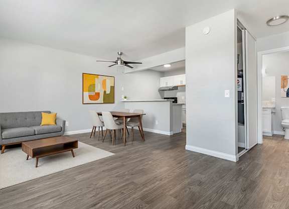 Model Living Room & Kitchen with Wood-Style Flooring at Accent on Rainbow Apartments located in Las Vegas, Nevada.