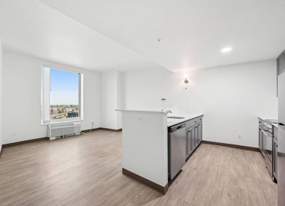 A kitchen with white appliances and wooden floors.